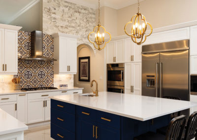 newly renovated kitchen featuring dark blue cabinetry on the central island