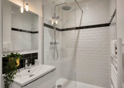 Bathroom Renovation features new high shine white subway tiling.