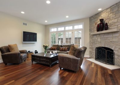 Bright and modern renovated living room with new hardwood floors and fresh paint and classic fireplace