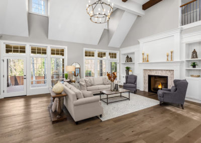 Living room features vaulted ceilings, fireplace with roaring fire, and elegant furnishings.