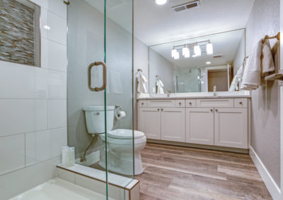 Elegant master bathroom with double vanity cabinet over hardwood floor.