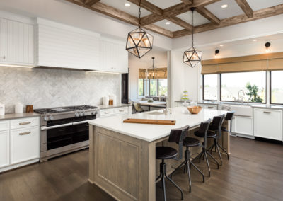 Kitchen Interior with Island, Sink, Cabinets, and Hardwood Floors in New Luxury Home