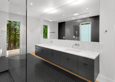 Sleek custom made double vanity with white quartz countertop and balck cermic tiles and free standing bathtub