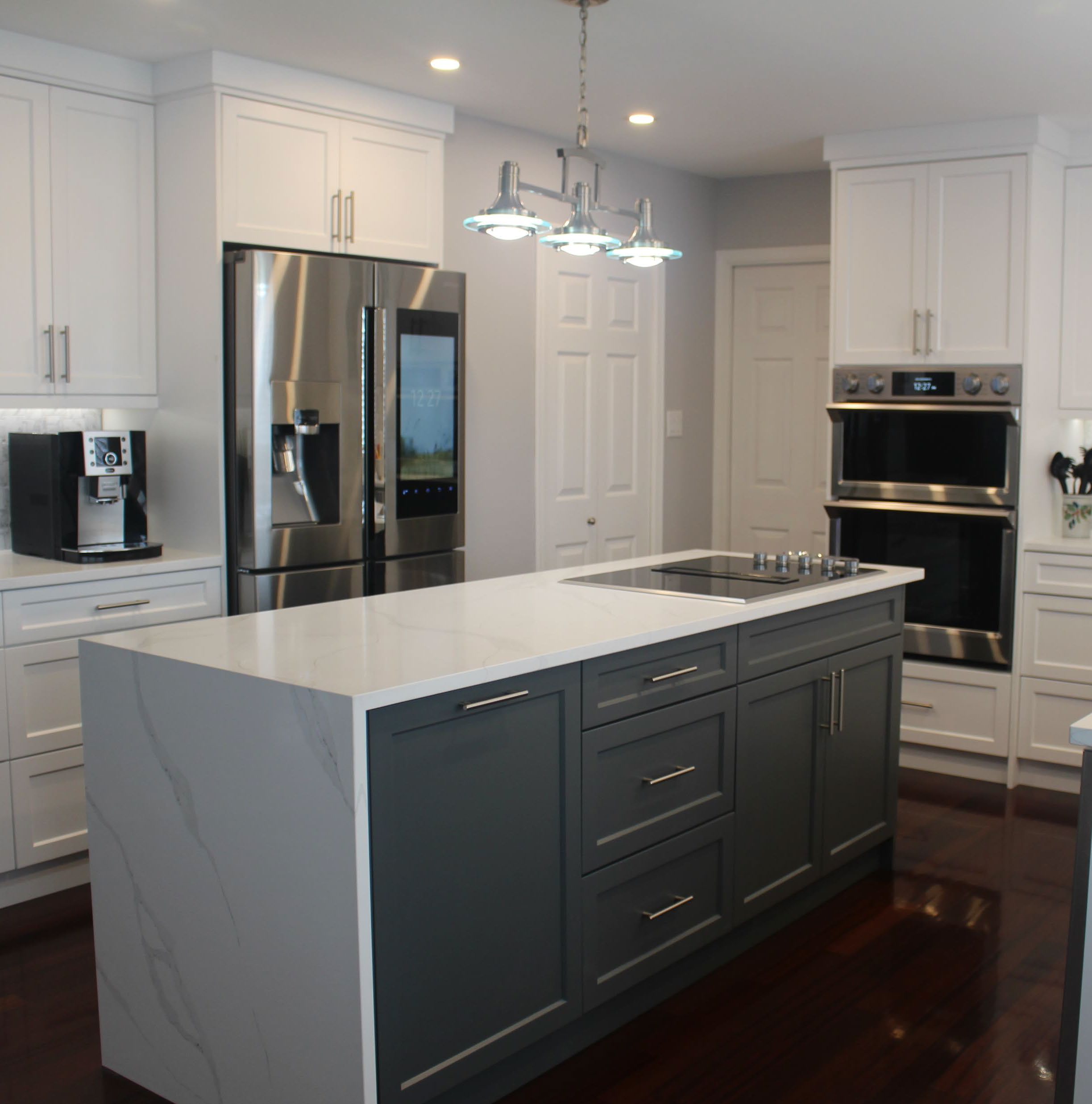 Custom-made kitchen cabinets with grey island cabinets and waterfall countertop