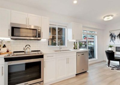 Renovated kitchen in a condo with white shaker panels and paige flooing and fresh paint