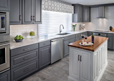 Stunning renovated kitchen with grey shaker panel cabinets and a white center island. The open concept design and natural light create a spacious and inviting atmosphere. The grey color scheme and modern finishes give the space a sophisticated and contemporary feel