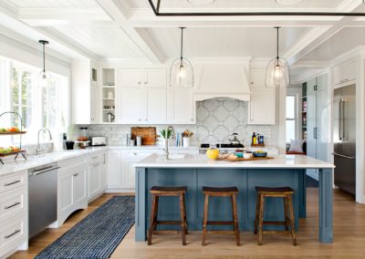 Beautifully renovated kitchen with white shaker panel cabinets and a blue center island with a butcher block countertop. The open concept design and natural light create a spacious and inviting atmosphere. The white and blue color scheme adds a modern and inviting touch to the space, perfect for entertaining or relaxing with family. Features include new appliances and sleek quartz countertops